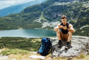 Picture of person doing mobile banking on a mountain
